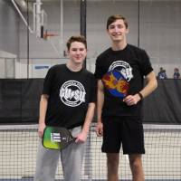 Students wearing championship shirts from a pickleball tournament